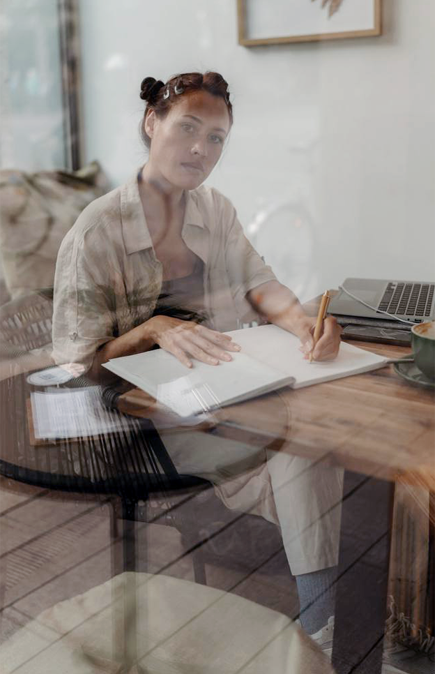 Author Laura Nguyen Chi writing by hand on a notepad.